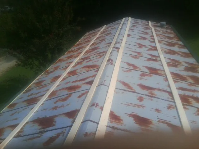 Rusted metal roof panels with new wood purlins before replacement — Storm Damage Roof Repair in Cove City by Roofing Brothers